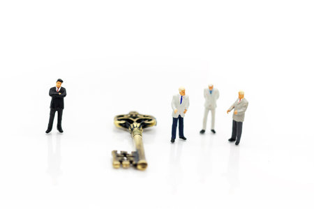 Miniature businessman handshake with unlock the keys, agreement, investment, partnership and business conceptの写真素材