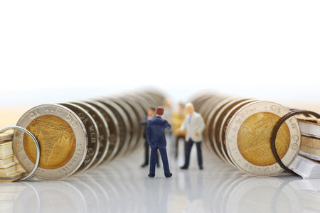 Miniature people:  Businessmen standing with coins stack, Finance, investment and growth in business concept.の写真素材