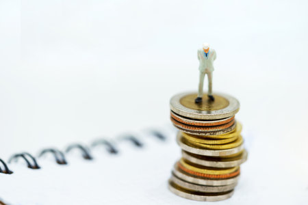 Miniature people:  Businessmen standing on coins stack, Finance, investment and growth in business...