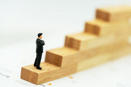 Miniature people: Business man standing on a wooden box.の写真素材