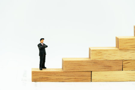Miniature people: Business man standing on a wooden box.の写真素材