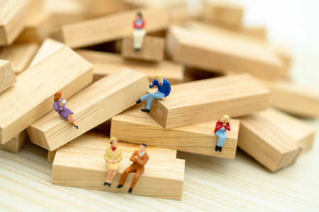 Miniature business people sitting on wood block , recruitment finding employee and business concept.の写真素材