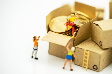 Miniature people climbing golden coins achieving top. Success, Finance, investment and growth in business concept.の写真素材