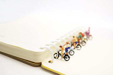 Miniature people parking on the book spine.の写真素材