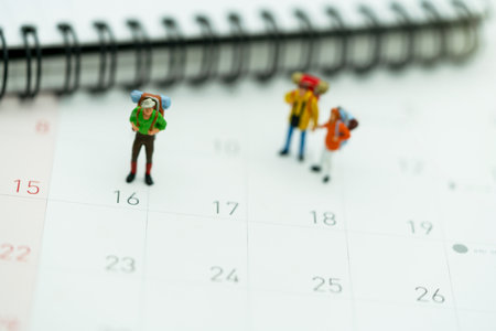 Miniature people: Tourists with backpacks standing on the travel calendar.の写真素材