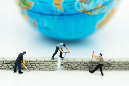 Miniature people: Worker fix the wall before the world. Concepts of finding a solution, problem solving and challenge.の写真素材