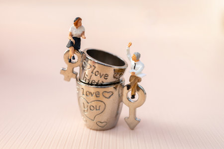 Miniature people Couple Lover sit on cup off coffee as pink background, lovely concept.
