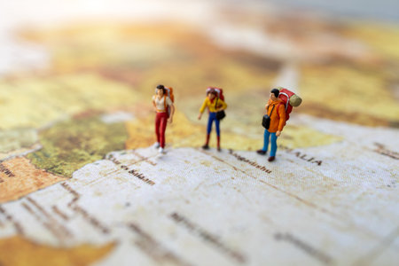 Miniature people: traveling with a backpack standing on vintage world map, Travel and vacation concept.の写真素材