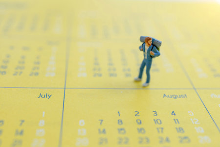 Miniature people: Traveler with a backpack standing on calendar, Travel and vacation Concepts.の写真素材