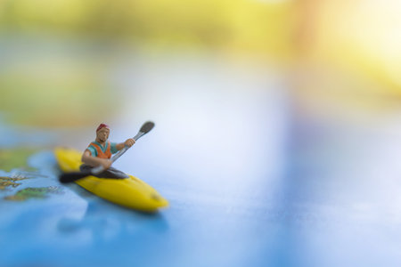Miniature people: Traveler sitting on board canoe and world map. Travel, vacation and  summer concept.の写真素材