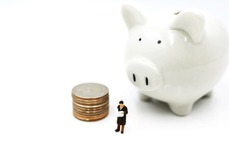 Miniature people: Elderly person standing  with coins stack and piggy bank, Retirement planning concept.の写真素材