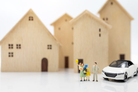 Miniature people: Parent and children standing with house and car. housing plan and family concept.の写真素材