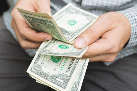 close up Business man in plaid shirt sitting hand hold Count the money spread of cash, . concept...