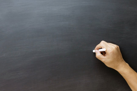 young teen hand to draw and writing something on blackboard with chalk. Education back to school concept / chalkboard. Leave blank empty space to write text.の写真素材