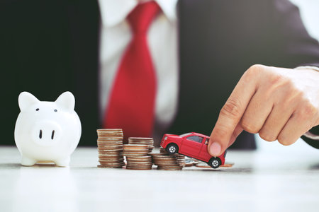 Business man in suit open hand prop up hug model of toy car on over a lot money of stacked coin insurance loan and buying car finance concept. buy and installment down payment a car. Piggy Bank savingの写真素材