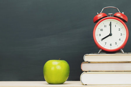 apple green,alarm clock red on book, put on the desk wooden stationery blackboard background. Education back to school concept. Leave empty copy space for text.の写真素材