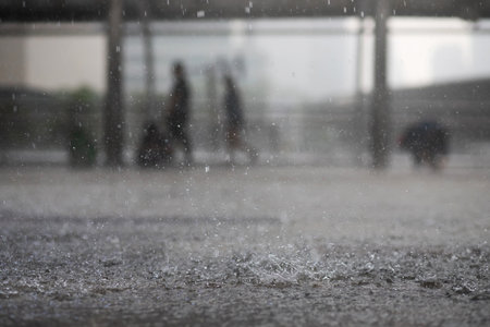 Rain drops in the water heavy on asphalt shade of black shadow and reflection of dark sky in the city. high contrast during autumn