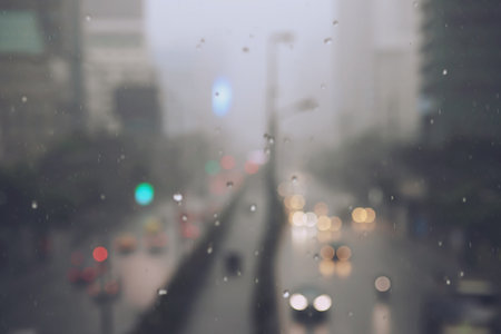 Drops Of Rain Drizzle on the glass windshield in the evening. street in the heavy rain. Bokeh Tail light. soft Focus. Please drive carefully, slippery road. soft focus.の写真素材