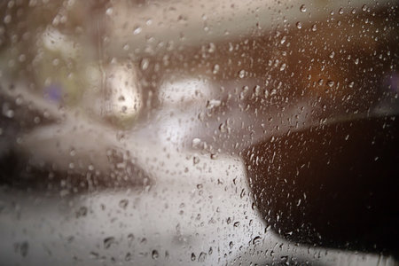 Drops Of Rain Drizzle on the glass windshield in the evening. street in the heavy rain. Bokeh Tail light. soft Focus. Please drive carefully, slippery road. soft focus.の写真素材