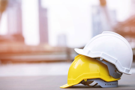 yellow and white hard safety wear helmet hat in the project at construction site building on...