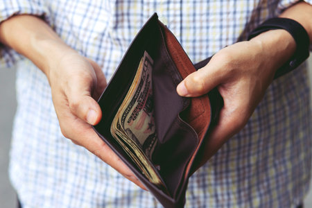 close up Businessman Person holding an wallet in the hands of an man take money out of pocket. finance conceptの写真素材