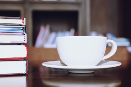 cup coffee on table in cafe. background style library book shelf Morning sunlight.の写真素材