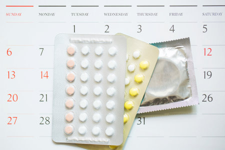 Contraceptive control pills and condom on date of calendar calculate date Control the birth rate. calendar background. health care and medicine, contraception concept. empty space for text.の写真素材