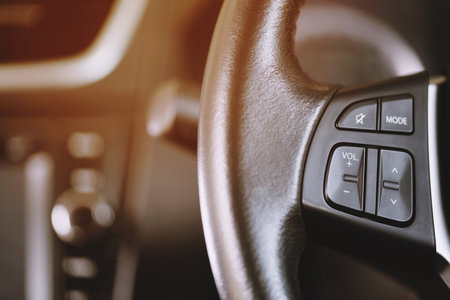 close up Modern black steering wheel with multifunction buttons Integrated stereo controls pushes the for quick control in the car.の写真素材