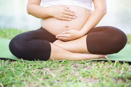 New mom Pregnant woman in white underwear have a backache Near the birth. Young woman expecting a baby Stand in the outdoors.の写真素材