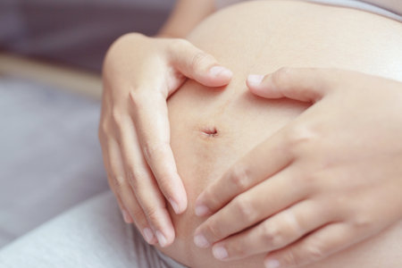 New mom Pregnant woman in white underwear Heart-shaped hand show love with baby. Young woman expecting a baby Stand in the outdoors.の写真素材