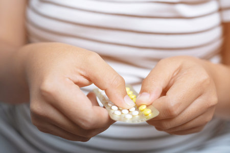 Woman hands opening birth control pills in hand. Eating Contraceptive Pill.の写真素材