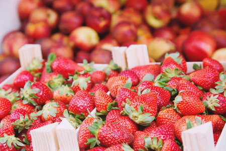 Fresh red Strawberries arranged in wooden boxes baskets ready for sale at marketplace at in farmer market. Fruit market. Retail. strawberry. backside apple backgroundの写真素材