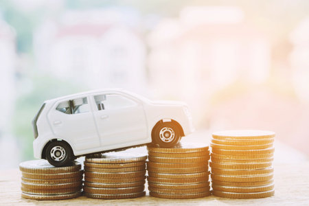 Little car over a lot of money stacked coins with background house. for loans costs finance concept. with filter Tones retro vintage effect ,Warm tones.の写真素材