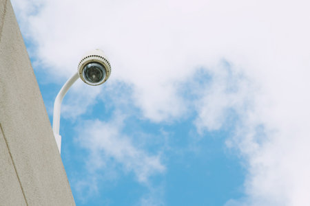 Security CCTV camera office building for monitor events, top view background sky.の写真素材