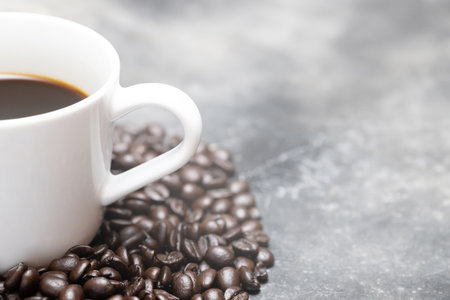 White coffee cup and coffee beans dark on table Bare mortar cement style loft background.の写真素材