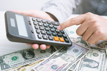 close up businessman hand using a calculator to calculate the numbers expenses. finance accounting saving money concept.の写真素材