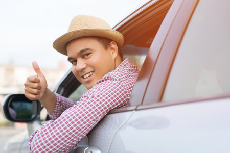 Man traveler ready to leave drive a car on the road. showing hand thumb up outdoor.の写真素材