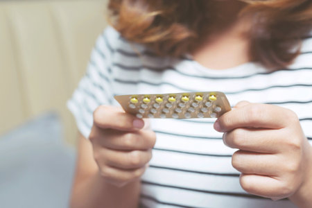 Woman hands give birth control pills in hand. Taking Contraceptive Pill.の写真素材