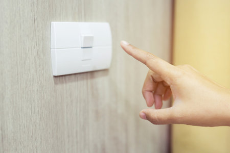 Turn off the light, close up female hand is closing the power switch. Save energy, reduce global...