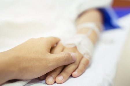 close up focus on the hand of a patient sick on the bed in hospital ward.の写真素材