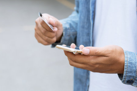 Online payment, Close up people man hands holding paying with credit card and using cell, smart phone for online shopping or reporting lost card, fraudulent transaction.の写真素材