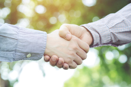 Close up of a business man hand shake between two colleagues greet , Represents Friendship is good,success, congratulations. copy leave space for text.の写真素材