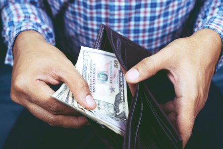 close up Businessman Person holding an wallet in the hands of an man take money out of pocket....
