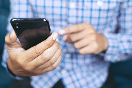 Young man Casual wear using on cell phone during rest in office. sitting sofa in watching message on mobile phone during break.の写真素材