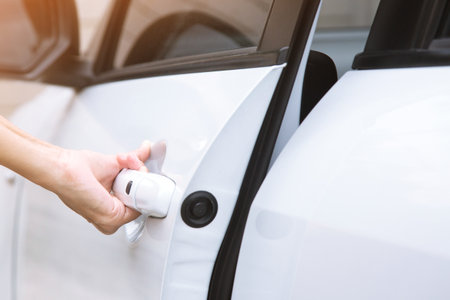 Hand on handle. Close up of man leather jacket suit hand opening a car door.の写真素材