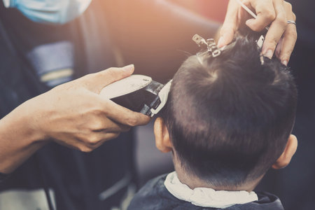 person man haircut getting stylish hair vintage shaving, with hair Scissors clipper and hair brush comb by barber hairdresser with hands at barbershop. filler Vintage Tone and Selective Soft Focus.の写真素材