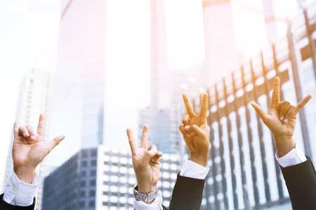 people businessman suit raising hand with two fingers and three fingers up in the peace or victory symbol symbol sign language The success of the organization.の写真素材