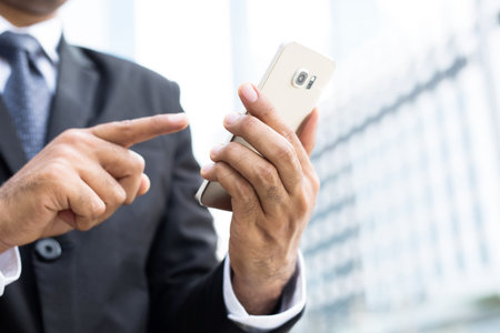 close up of businessman using telephone smart phone to contact the job. or Business man Contact Customer.の写真素材