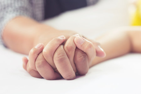 Hands stranglehold of couple lovers on a bed at honeymoon with lust and love. Concept about love, sex and lifestyle.の写真素材