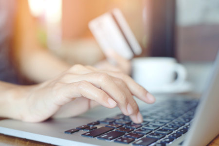 business woman hands holding credit card and using phone and computer laptop. Online shopping purchase Sell or Payment.の写真素材